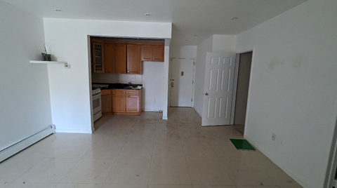 A kitchen with white walls and a tiled floor.