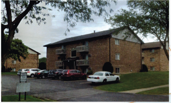 A parking lot with cars and a building in the background.
