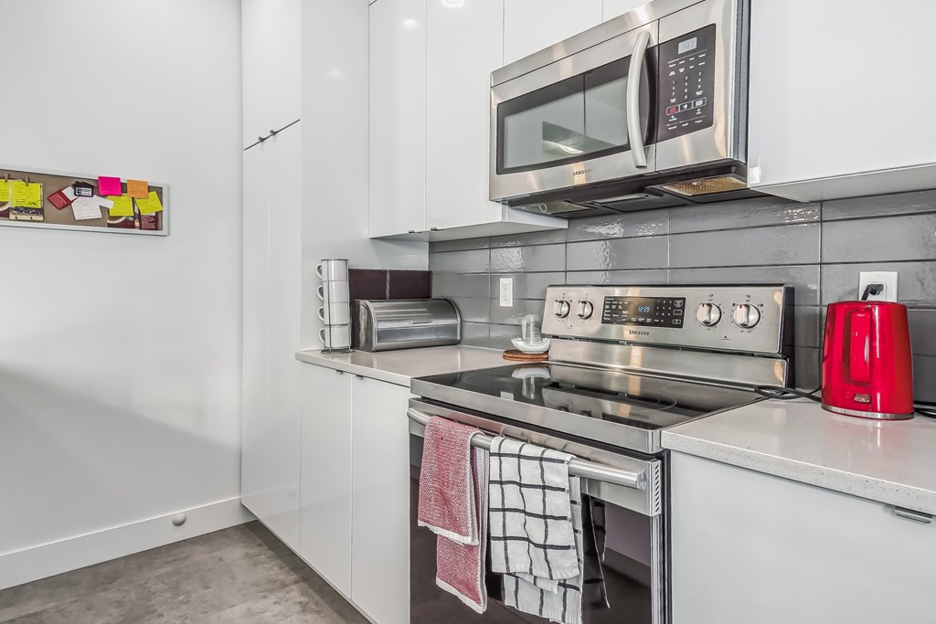 A modern kitchen with a stainless steel oven and microwave above the stove.