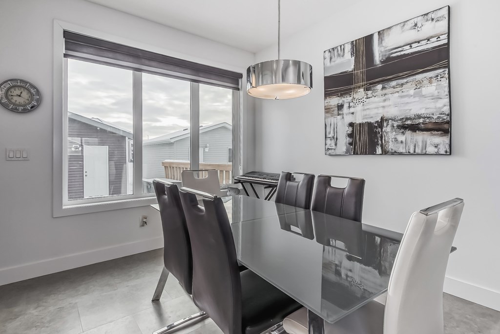 A modern dining room with a glass table and chairs.