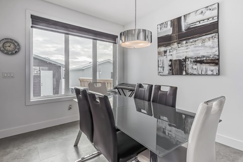 A modern dining room with a glass table and chairs.