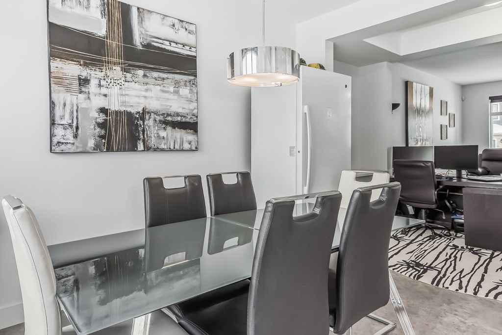 A modern dining room with a glass table and chairs.