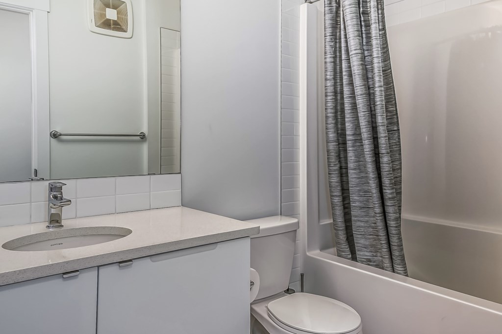 A white bathroom with a sink, toilet, and bathtub.