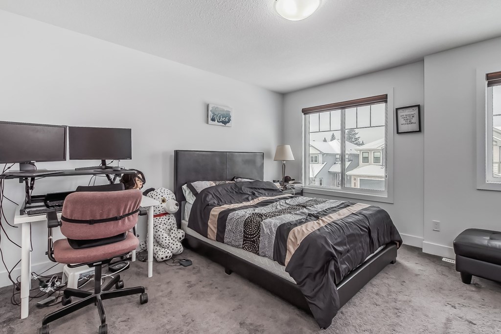 A bedroom with a bed, desk, and chair.