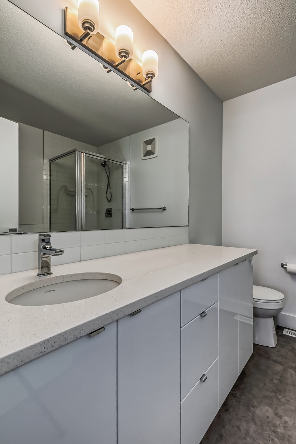 A bathroom with a sink, mirror, and toilet.