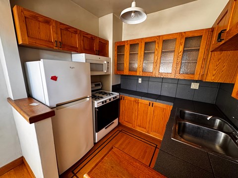 A kitchen with wooden cabinets and a white refrigerator.