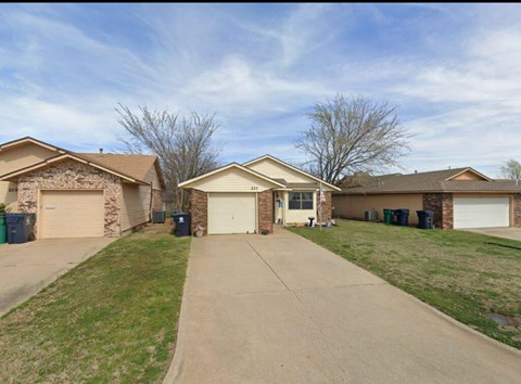 A row of houses with a driveway in the foreground.