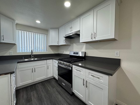 A kitchen with white cabinets and a black stove top oven.