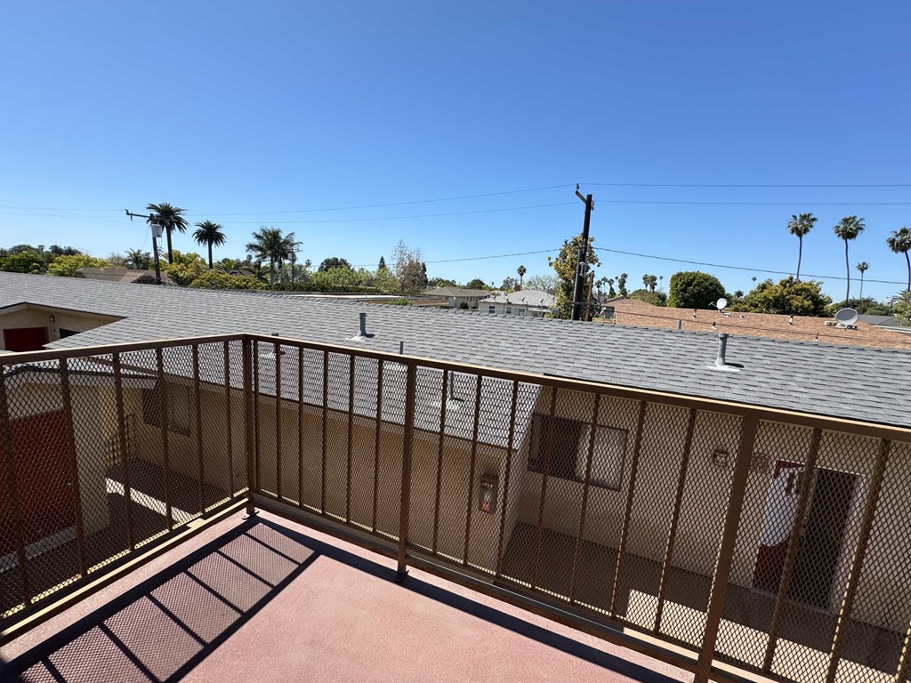 A balcony with a metal railing and a brown roof.