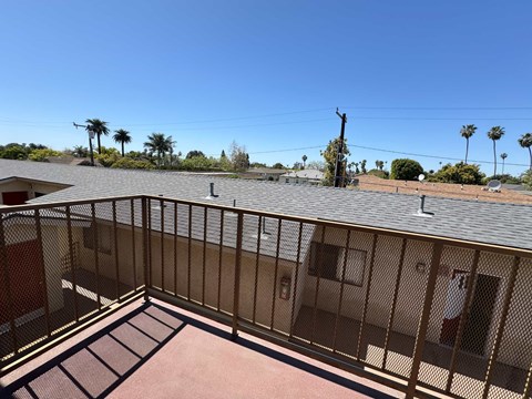 A balcony with a metal railing and a brown roof.