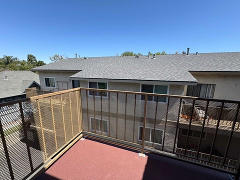 A balcony with a metal railing and a red carpet.