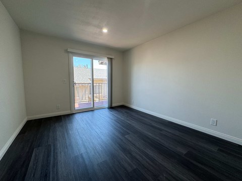 A room with a sliding glass door leading to a balcony.