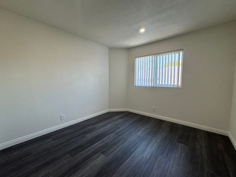 A room with a window and wooden flooring.