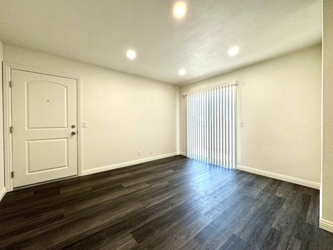 A room with a white door and a window with blinds.