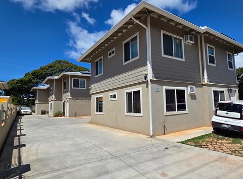 A modern two-story house with a grey and white exterior and a driveway in front.