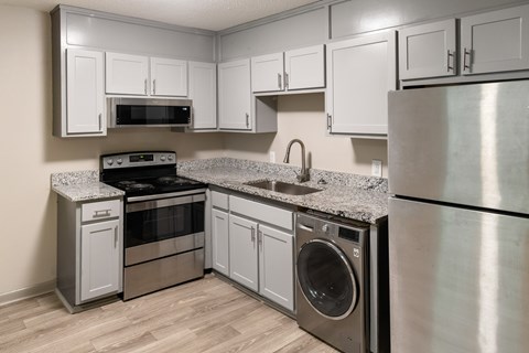 A modern kitchen with stainless steel appliances and white cabinets.