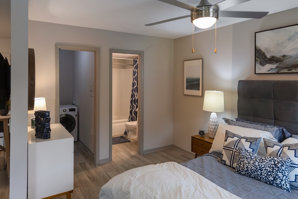 A bedroom with a bed, nightstand, and a ceiling fan.