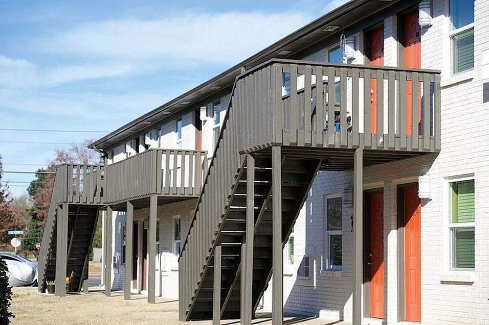 A wooden deck with stairs leading to a house.