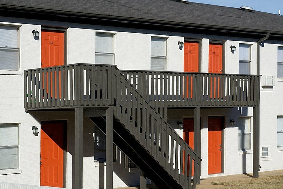 A building with a balcony and stairs leading to it.