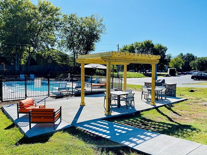 A sunny day at the poolside with a yellow canopy and orange chairs.