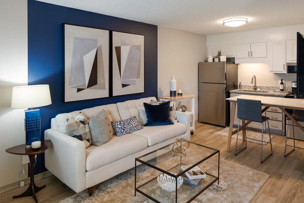 A modern living room with a white couch and a glass coffee table.