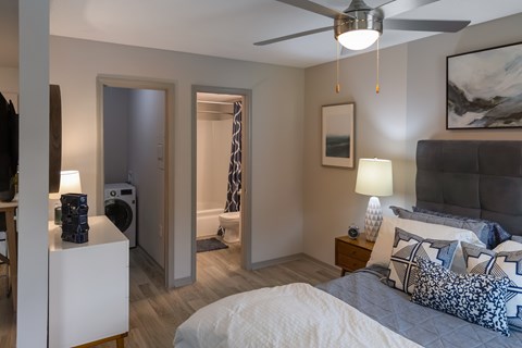A bedroom with a bed, nightstand, and a ceiling fan.