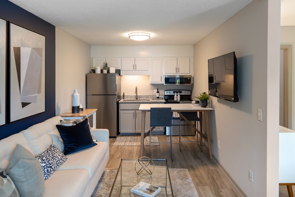 A modern living room with a white couch and a glass coffee table.
