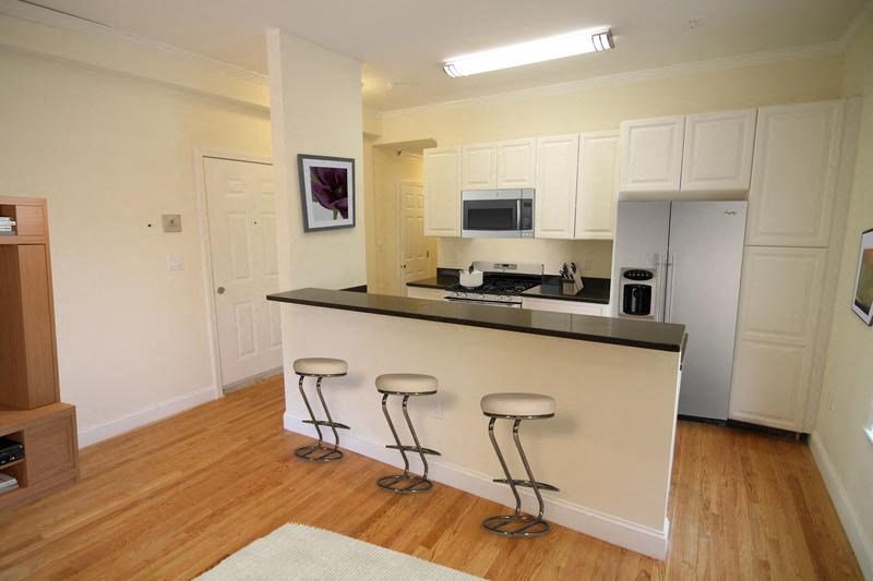 a kitchen with a bar with three stools