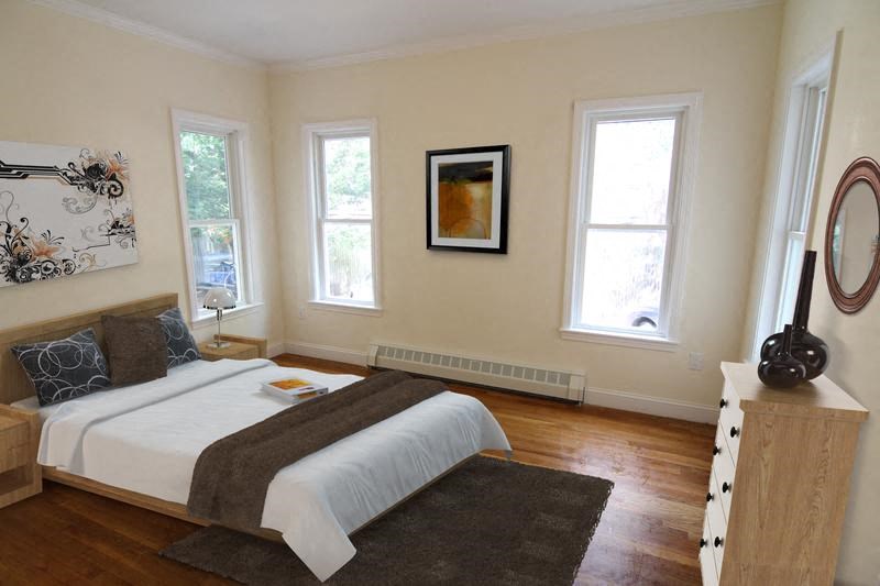 a bedroom with a bed and three windows