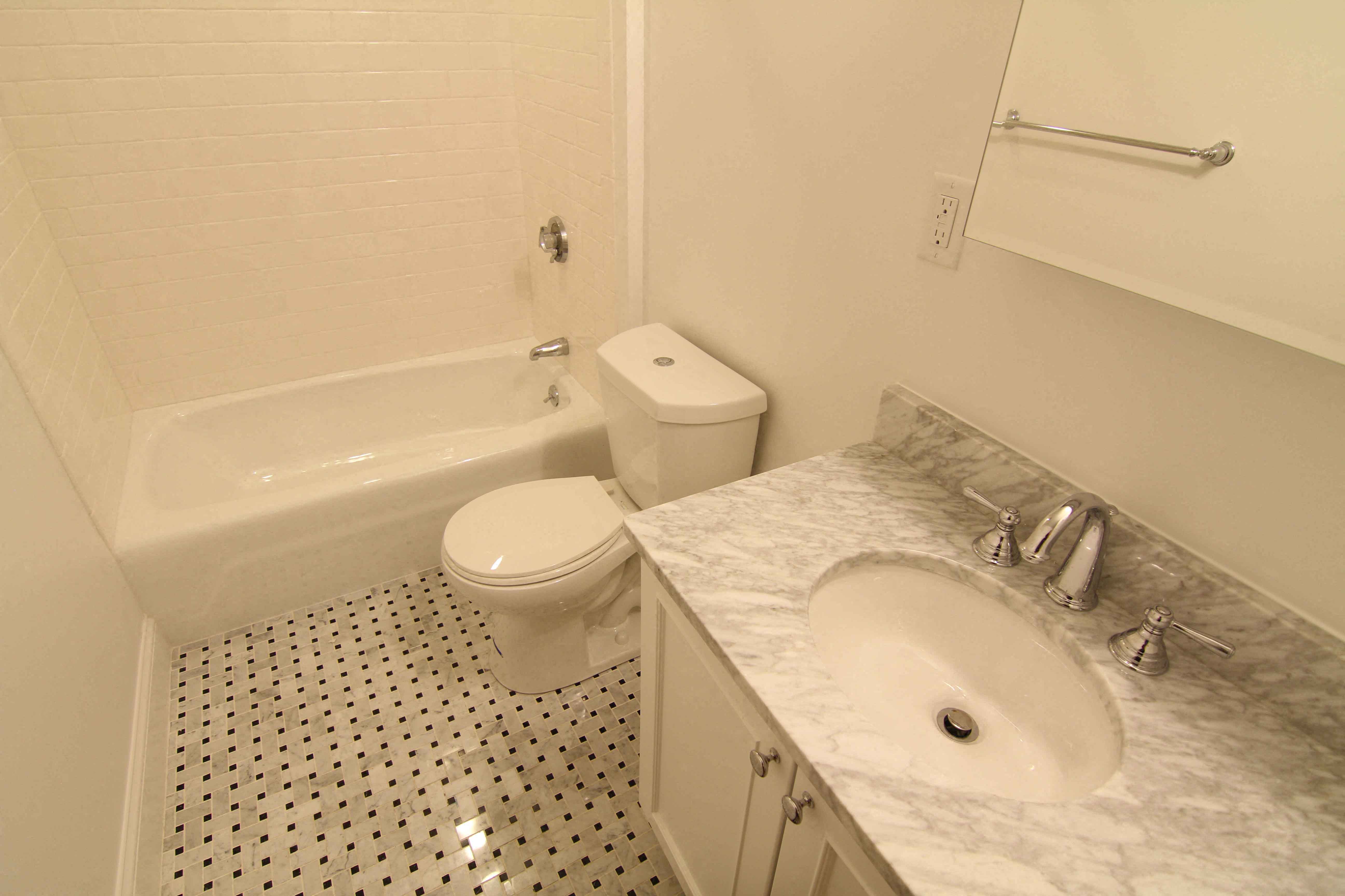a bathroom with a toilet and a sink and a bath tub