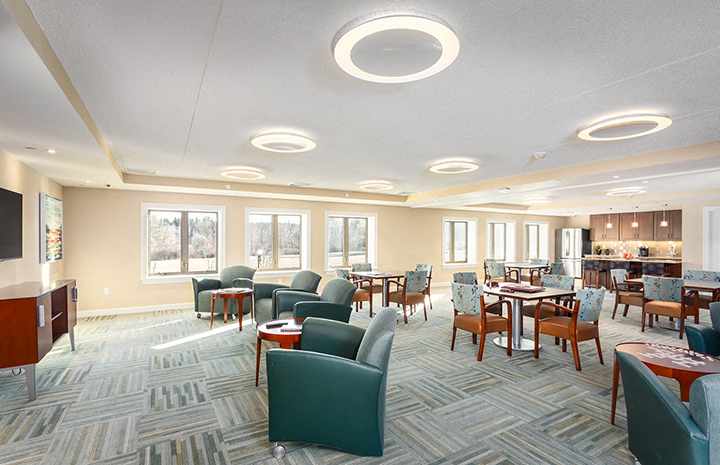 a large room with chairs and tables and windows