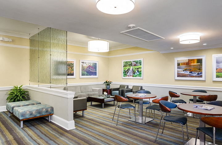 a lounge area with tables and chairs and a reception desk