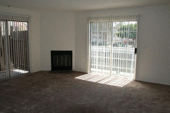A room with a fireplace and a window with bars.