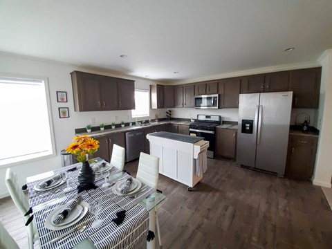 A kitchen with brown cabinets and a checkered tablecloth.