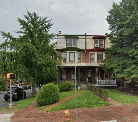 A house with a red brick walkway in front of it.