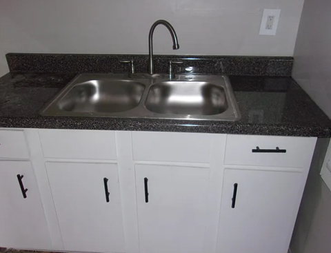 A kitchen with a sink and cabinets.
