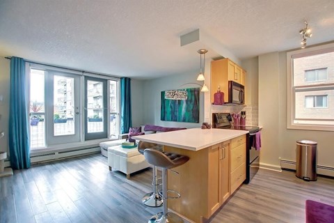 A kitchen with wooden cabinets and a white island.