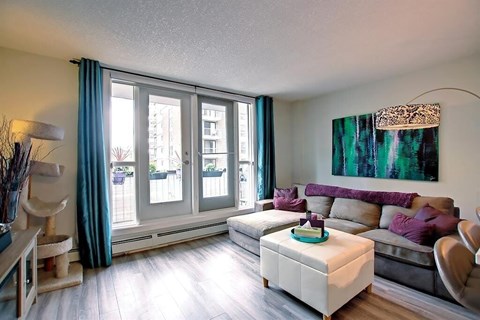 A living room with a grey couch and a large window.