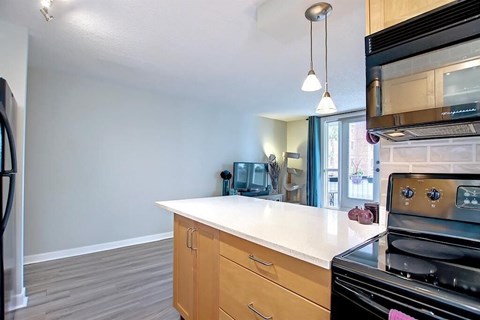 A kitchen with a black stove top oven and a white counter top.