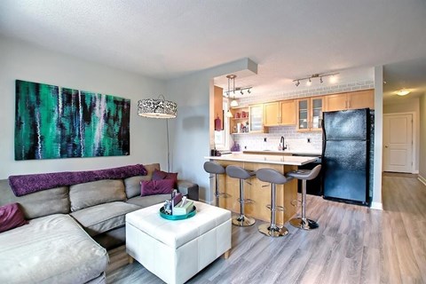 A modern living room with a bar and kitchen area.