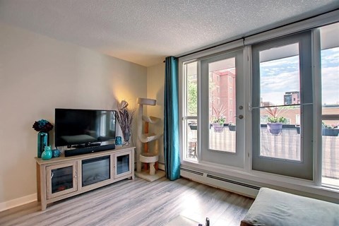 A living room with a television and sliding glass doors.