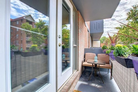 A patio with a table and chairs is visible through a glass door.