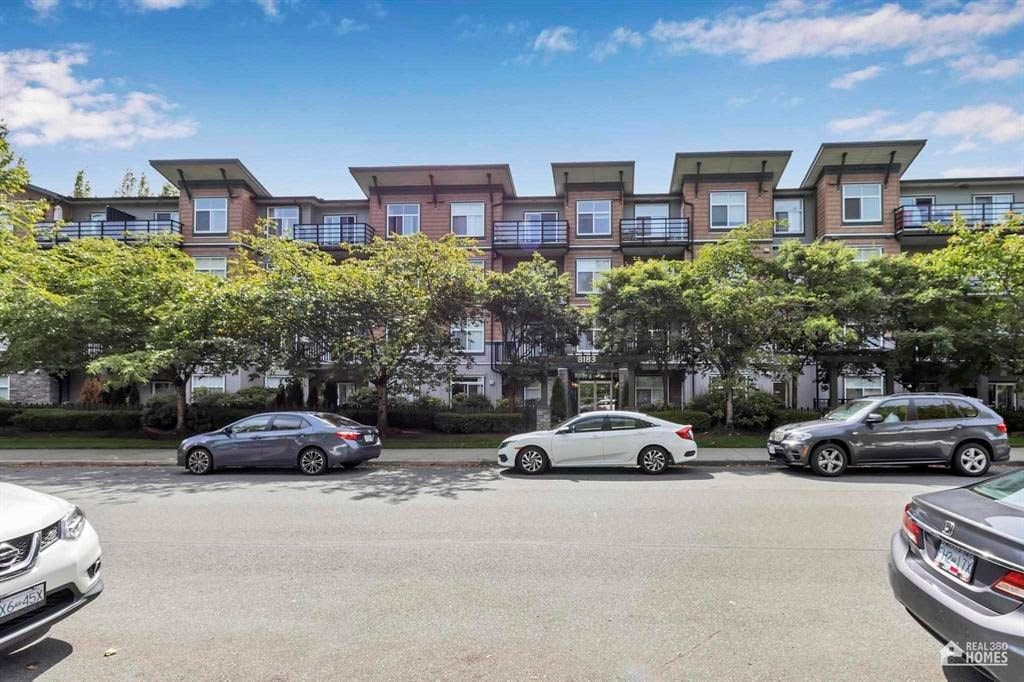 A row of townhouses with cars parked in front.