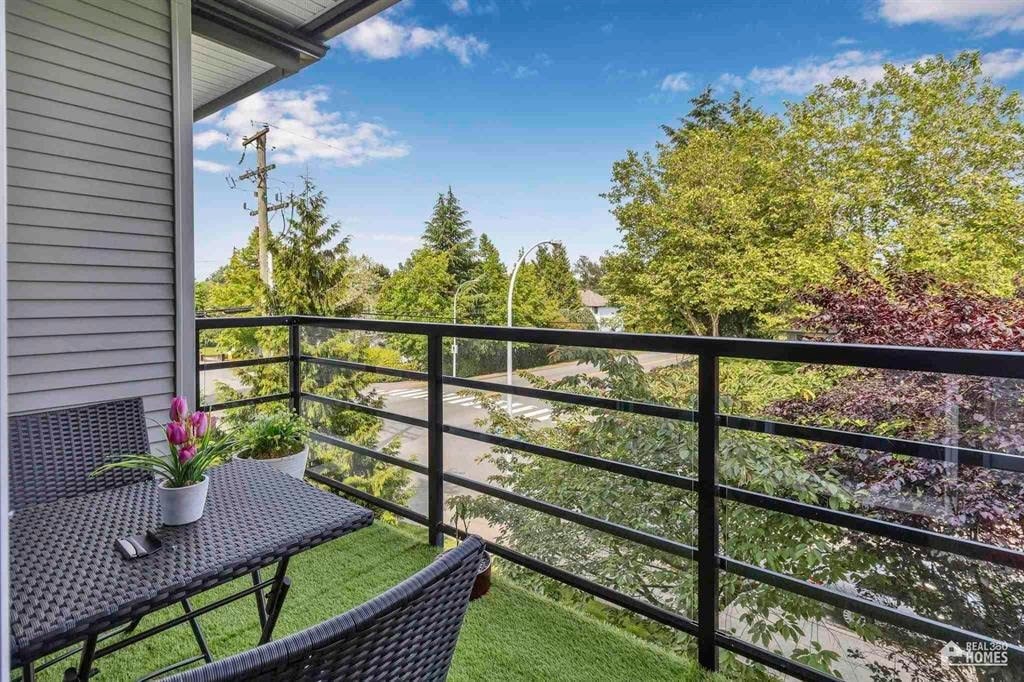 A patio with a table and chairs overlooking a green yard.