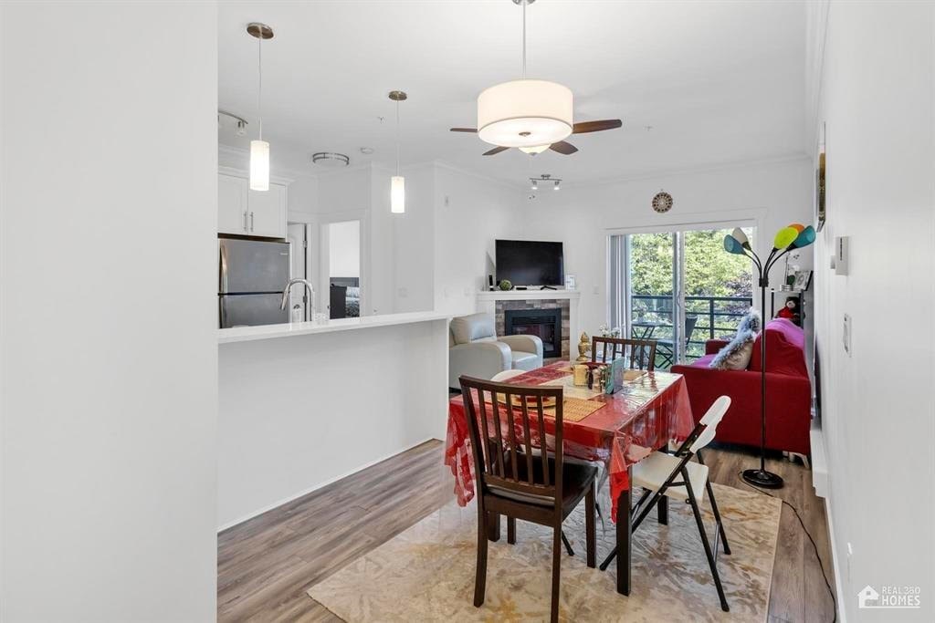 A dining room with a table set for two and a television in the corner.