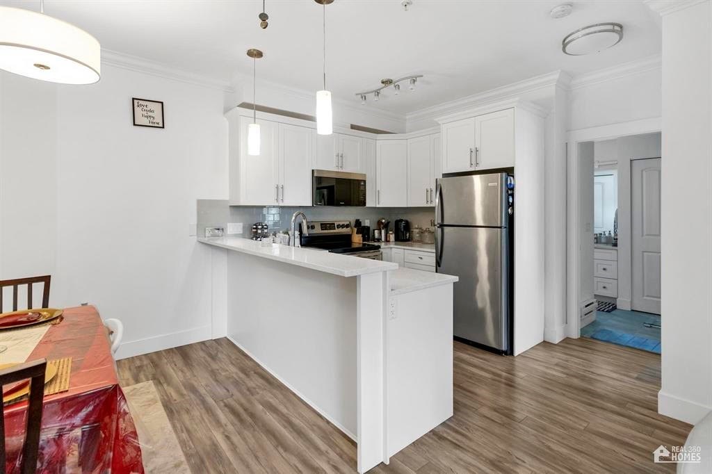 A kitchen with a refrigerator, stove, and oven.