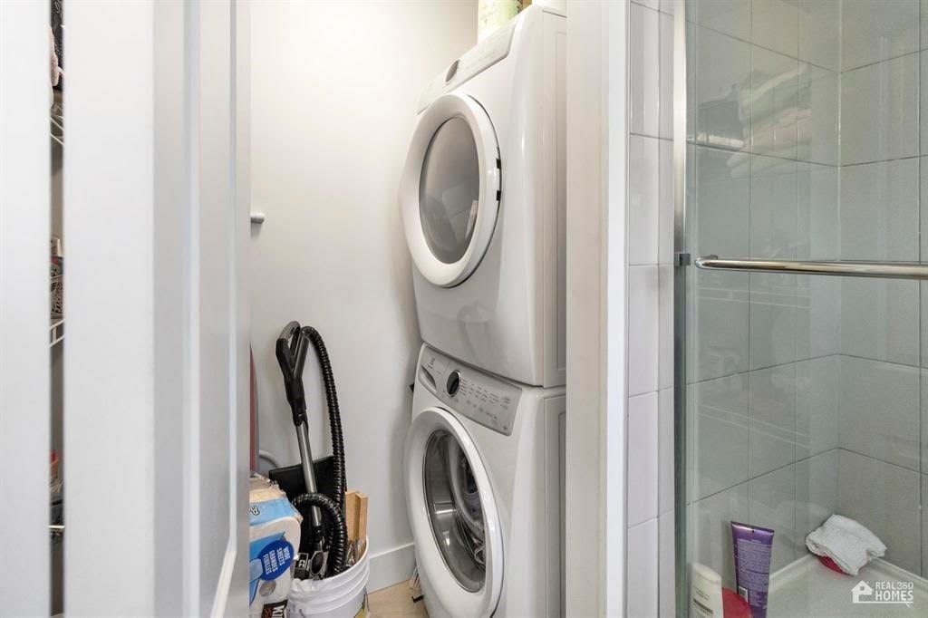A white washing machine is in a small laundry room.