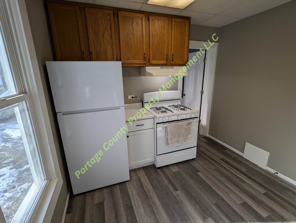 A kitchen with a white fridge and a white stove top oven.