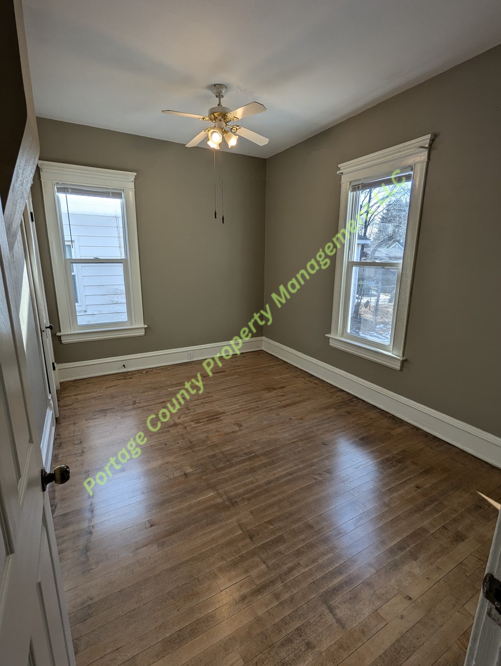 A room with wooden flooring and a ceiling fan.