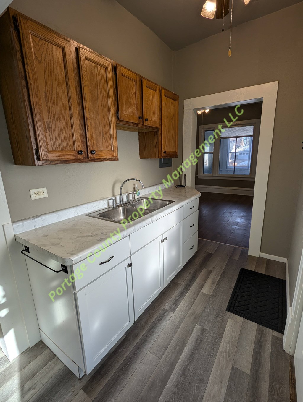 A kitchen with white cabinets and a marble countertop.